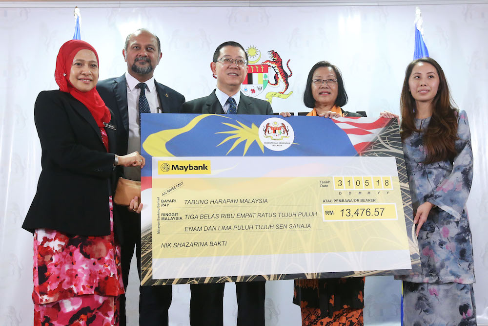 Finance Minister Lim Guan Eng receives a mock cheque for Tabung Harapan Malaysia at the Ministry of Finance in Putrajaya May 31, 2018. u00e2u20acu201d Picture by Azinuddin Ghazali 