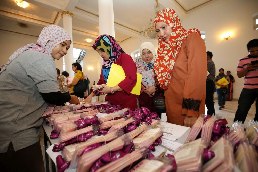 Workers and volunteers who will be on duty for polling day tomorrow collect their tags from the Election Commission in Ipoh May 8, 2018. u00e2u20acu201d Picture by Marcus Pheong