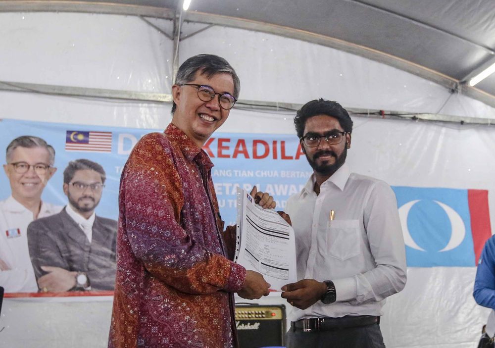 Former Batu MP Tian Chua receiving the application forms to join PKR from Batu MP P. Prabakaran in Sentul, May 13, 2018. u00e2u20acu201d Picture by Firdaus Latif