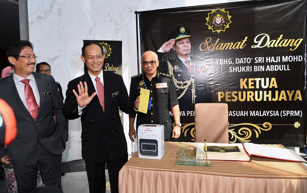 Datuk Seri Mohd Shukri Abdull (second left) clocks in at the Malaysian Anti-Corruption Commission headquarters in Putrajaya May 21, 2018. u00e2u20acu201d Bernama pic