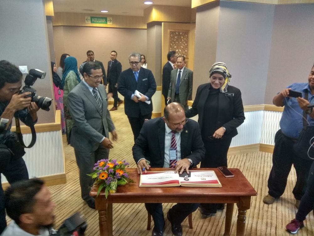 Gobind signs his attendance before a briefing session with department heads while chief secretary Tan Sri Sharifah Zarah Syed Ahmad (right) looks on. u00e2u20acu2022 Picture by Kenneth Tee
