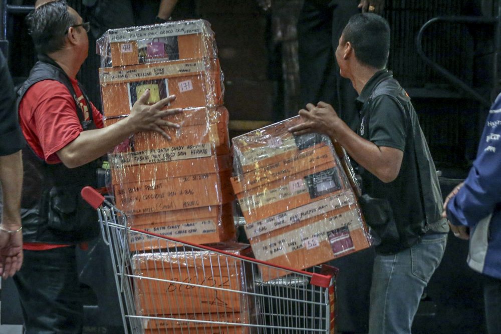Investigators lift sealed boxes believed to contain luxury designer bags onto a Black Maria outside Pavilion Residences in Kuala Lumpur May 18, 2018. u00e2u20acu201d Picture by Hari Anggara  