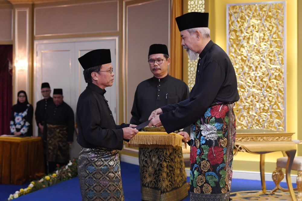 Tun Juhar Mahiruddin menyampaikan watikah pelantikan kepada Datuk Seri Mohd Shafie Apdal sebagai ketua menteri Sabah pada istiadat angkat sumpah jawatan di Istana Negeri 12 Mei 2018. u00e2u20acu201d Foto Bernama n