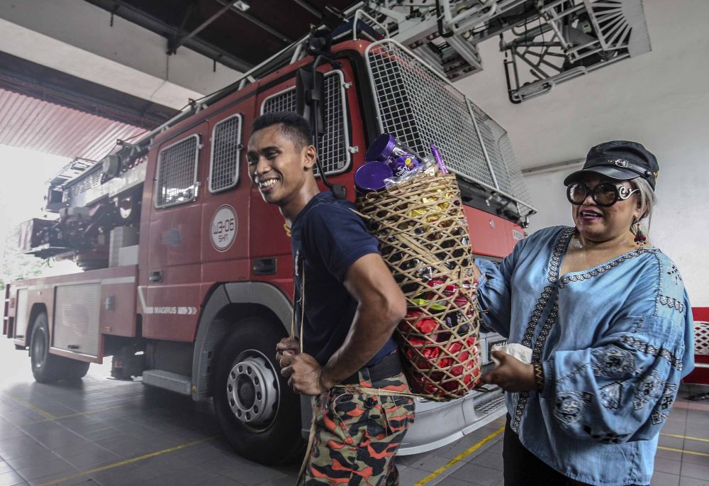 Firemen from Balai Bomba Sri Hartamas receive chocolates from Siti Kasim in Kuala Lumpur May 26, 2018. u00e2u20acu2022 Picture by Firdaus Latif
