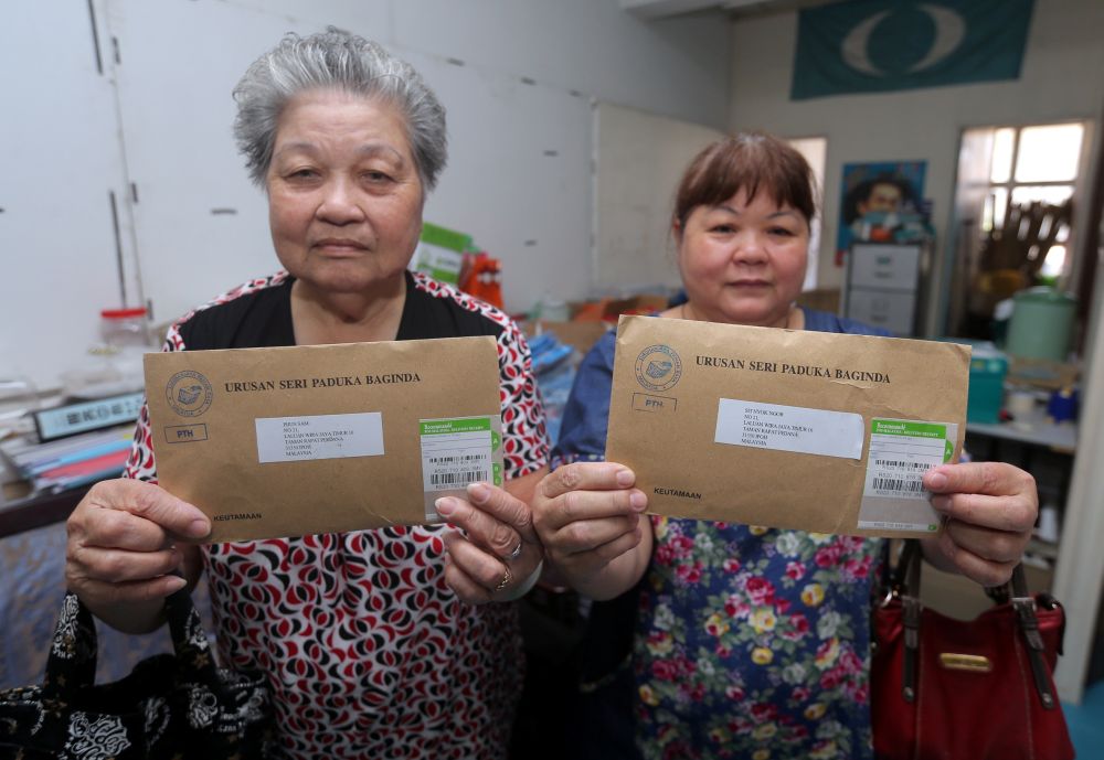 Sit Nyok Ngor and her mother Phun Sam (left) showing the postal votes they received on Wednesday. Sit and her mother had never registered to vote as postal voters. u00e2u20acu2022 Picture by Farhan Najib