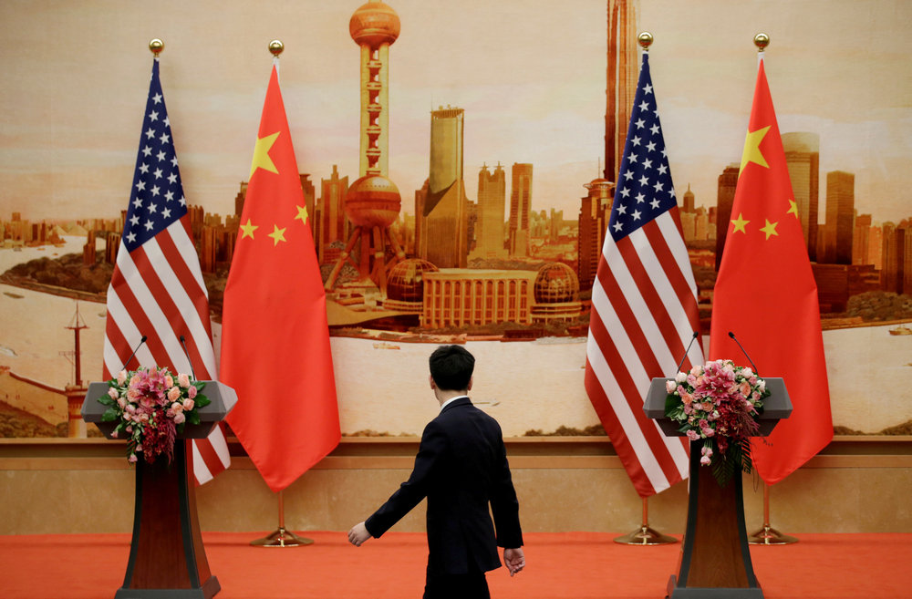 A staff member walks past US and Chinese flags placed for a joint China-US trade news conference at the Great Hall of the People in Beijing June 14, 2018. u00e2u20acu201d Reuters pic