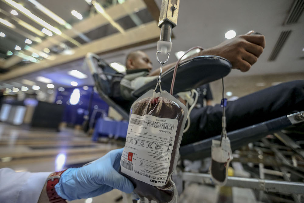 A Polapol trainee donating blood during the blood donation campaign in conjunction with the 211th Police Day in Bukit Aman July 11, 2018. u00e2u20acu201d Picture by Hari Anggara