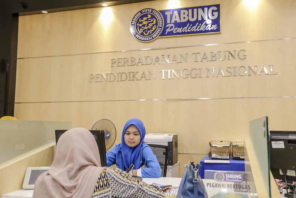 An employee serves a customer at the National Higher Education Fund Corporation (PTPTN) in Kuala Lumpur July 16, 2018. u00e2u20acu201d Picture by Firdaus Latif