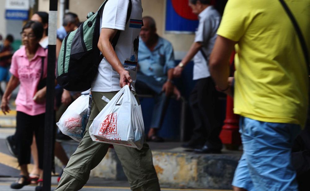 A man is pictured carrying a plastic bag of food in Komtar July 23, 2018. u00e2u20acu201d Picture by Sayuti Zainudin