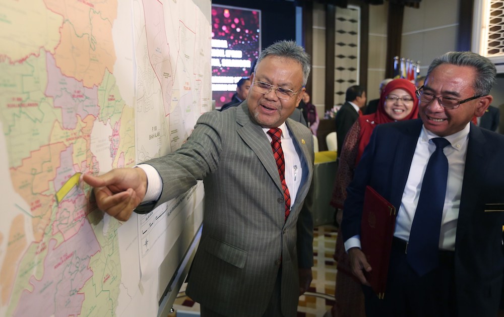 SPR deputy chairman Tan Sri Othman Mahmood (left) and returning officer Datuk Mohd Azizi Mohd Zain showing a map of Seri Setia for the upcoming by-election, August 8, 2018. u00e2u20acu201d Picture by Razak Ghazali