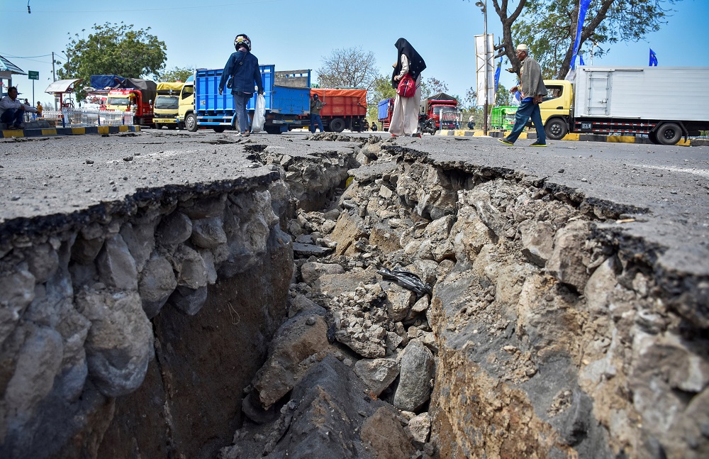 People walk near a road damaged by yesterday's large earthquake at Kayangan Port in Lombok, Indonesia August 20, 2018 in this photo taken by Antara Foto. u00e2u20acu201d Reuters pic