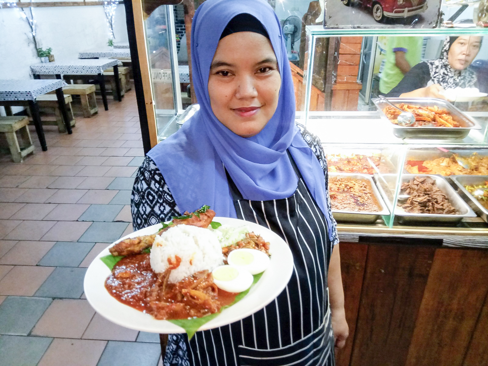 诺拉扎现在负责烹煮每天售卖的椰浆饭。-R. Rohaizam摄-