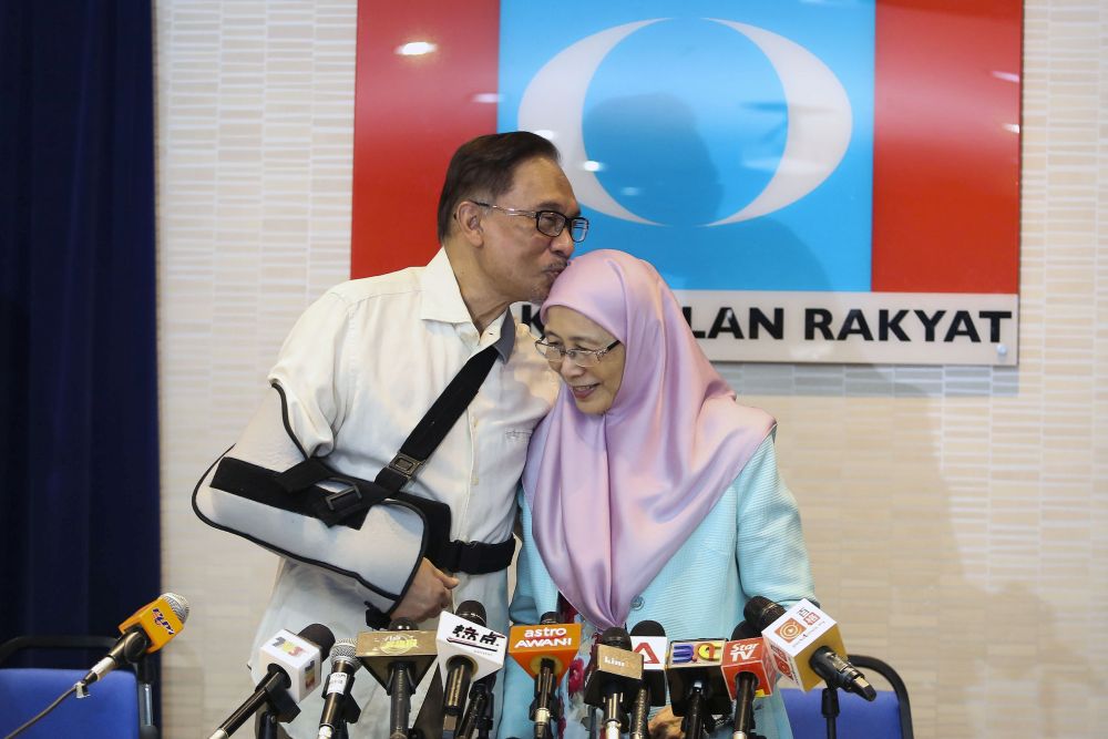 Datuk Seri Anwar Ibrahim kisses his wife Datin Seri Wan Azizah Wan Ismail during a press conference at PKRu00e2u20acu2122s headquarters in Petaling Jaya on August 9, 2018. u00e2u20acu201d Picture by Yusof Mat Isa