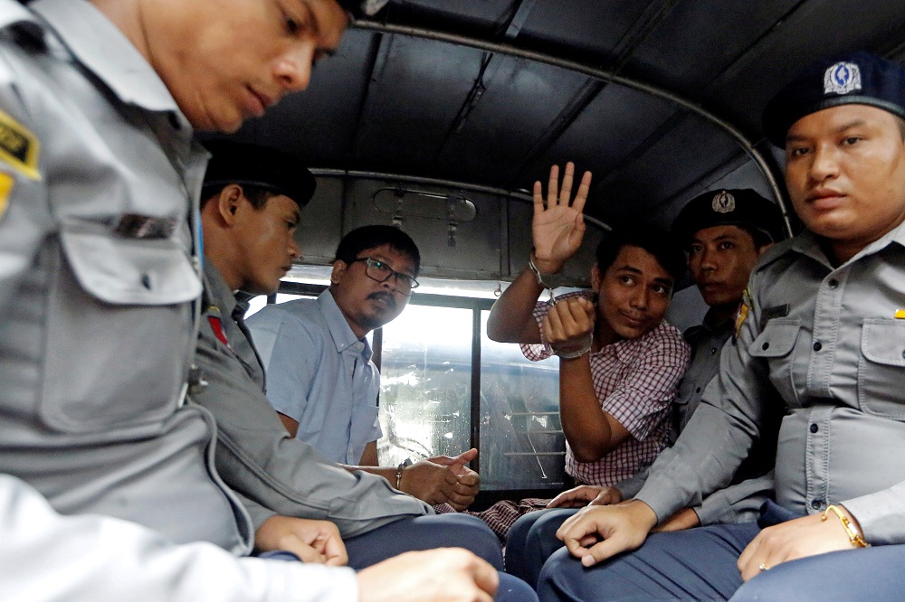Detained Reuters journalists Wa Lone and Kyaw Soe Oo sit beside police officers as they leave Insein court in Yangon, Myanmar July 9, 2018. u00e2u20acu201d Reuters pic