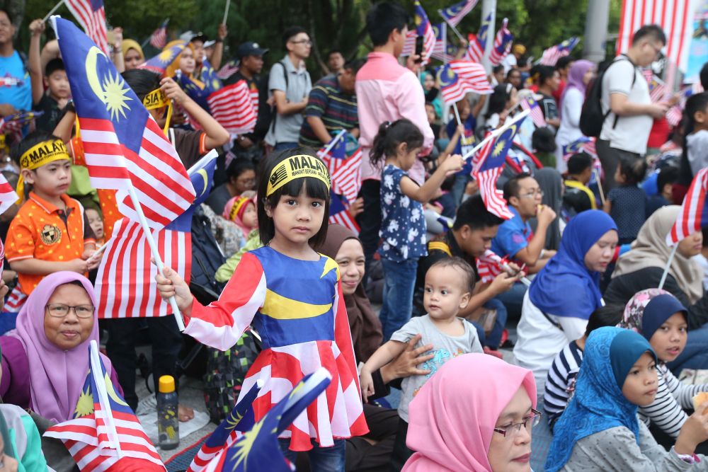 A child is pictured waving the 'Jalur Gemilang' at Dataran Putrajaya August 31, 2018. u00e2u20acu201d Picture by Azinuddin Ghazali