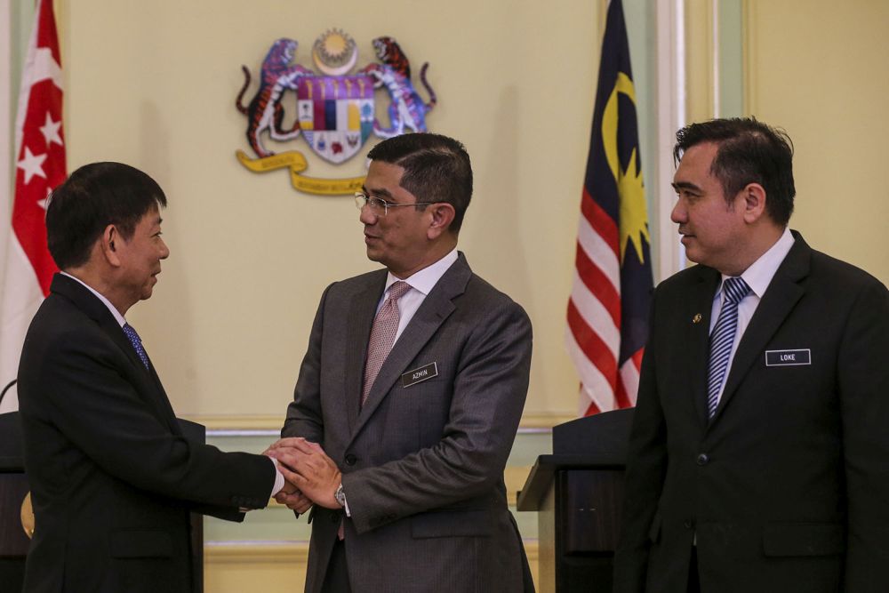 Minister of Economic Affairs, Datuk Seri Mohamed Azmin Ali (centre) shakes hands with Singapore Transport Minister Khaw Boon Wan during a news conference in Putrajaya September 5, 2018. u00e2u20acu2022 Picture by Hari Anggarann