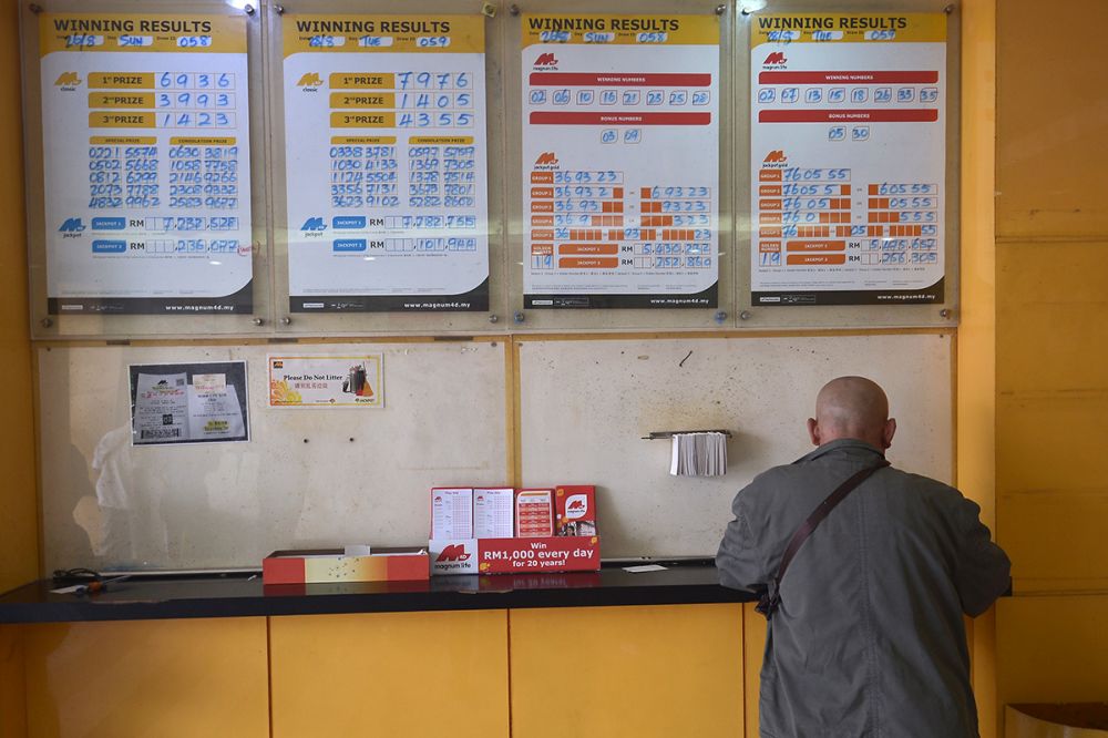 A man buys tickets at a Magnum 4D outlet in Kuching, August 28, 2018. u00e2u20acu201d Picture by Mukhriz Hazim