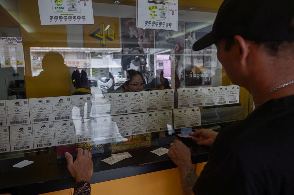 A man buys tickets at a Magnum 4D outlet in Kuching, August 28, 2018. u00e2u20acu201d Picture by Mukhriz Hazim