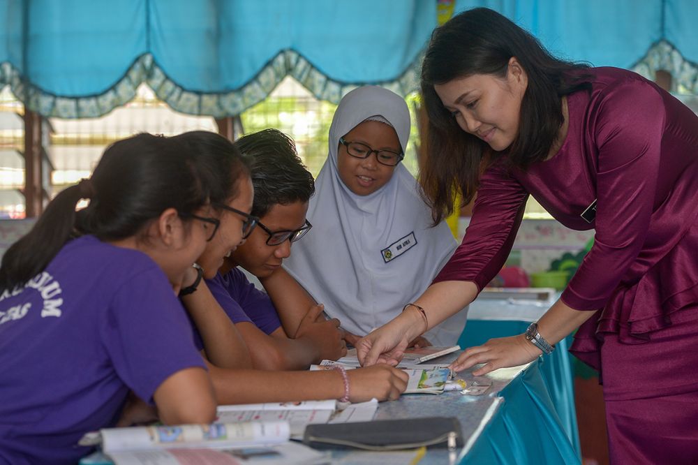 Teacher Tracy Neddy teaches her students after they received their spectacles at SK Atas Singai in Kuching August 29, 2018. u00e2u20acu2022 Picture by Mukhriz Hazim
