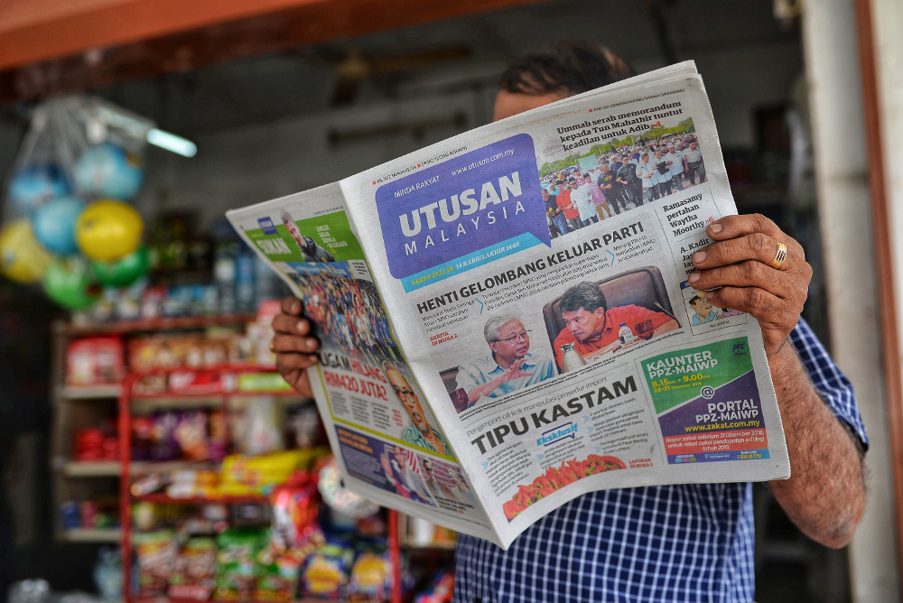 A reader is seen reading the Utusan Malaysia newspaper in Sungai Besi, Kuala Lumpur December 22, 2018. u00e2u20acu201d Picture by Shafwan Zaidon