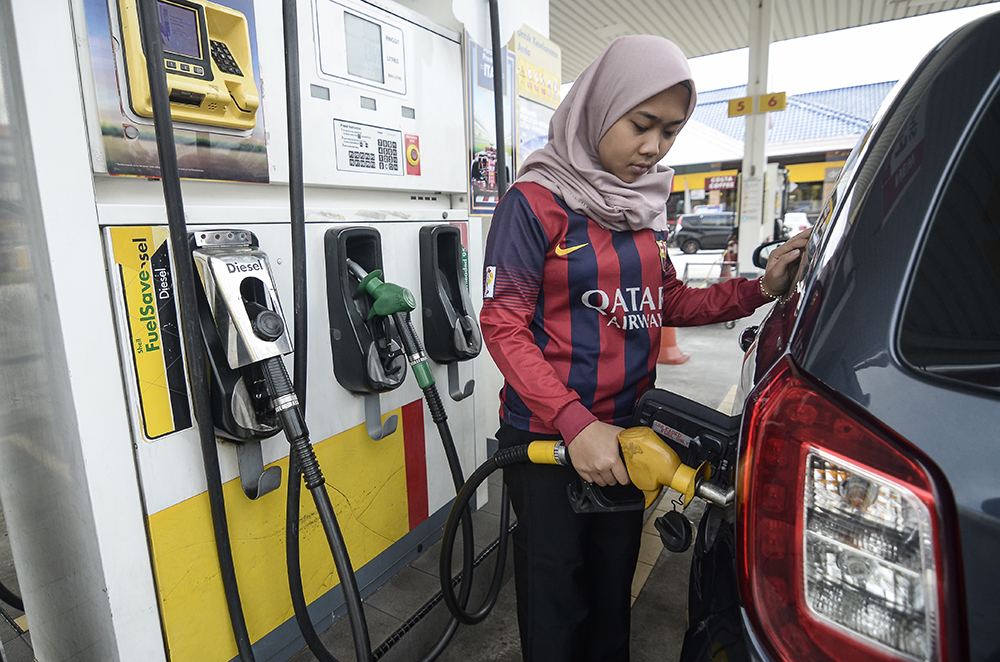 Nurisofi Ahmad pumps fuel into her car at a petrol station in Puchong Permai December 27, 2018. u00e2u20acu201d Picture by Miera Zulyana