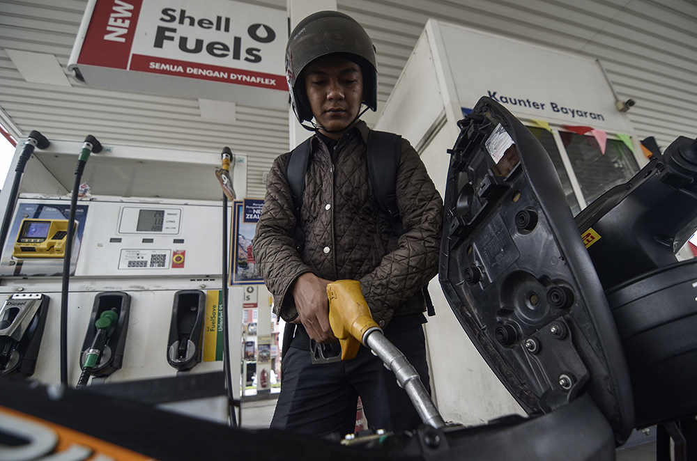 Syed Hazeeq pumps fuel into his motorcycle at a petrol station in Puchong Permai December 27, 2018. u00e2u20acu201d Picture by Miera Zulyana