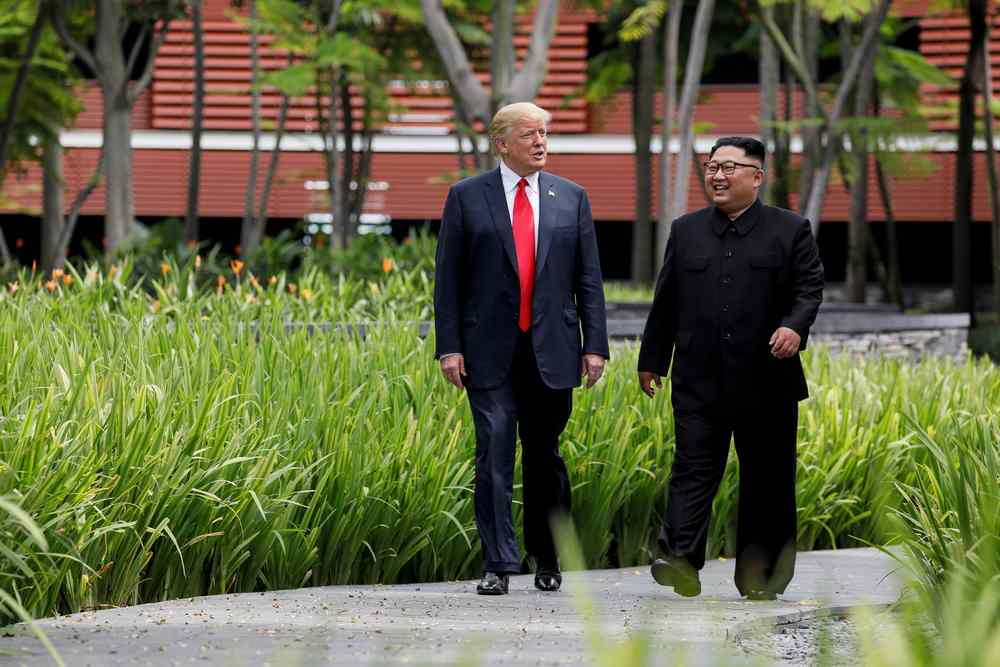 US President Donald Trump and North Korea's leader Kim Jong Un walk together before their working lunch on the resort island of Sentosa, Singapore June 12, 2018. u00e2u20acu201d Reuters