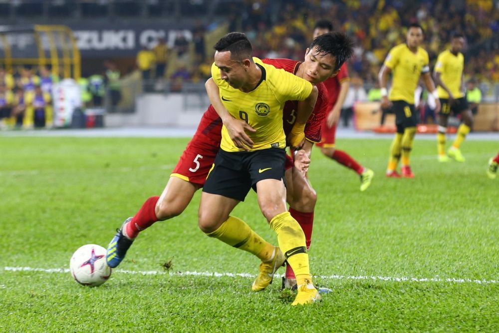 马来虎诺沙鲁（前）和越南球员拼抢中。-Ahmad Zamzahuri摄-