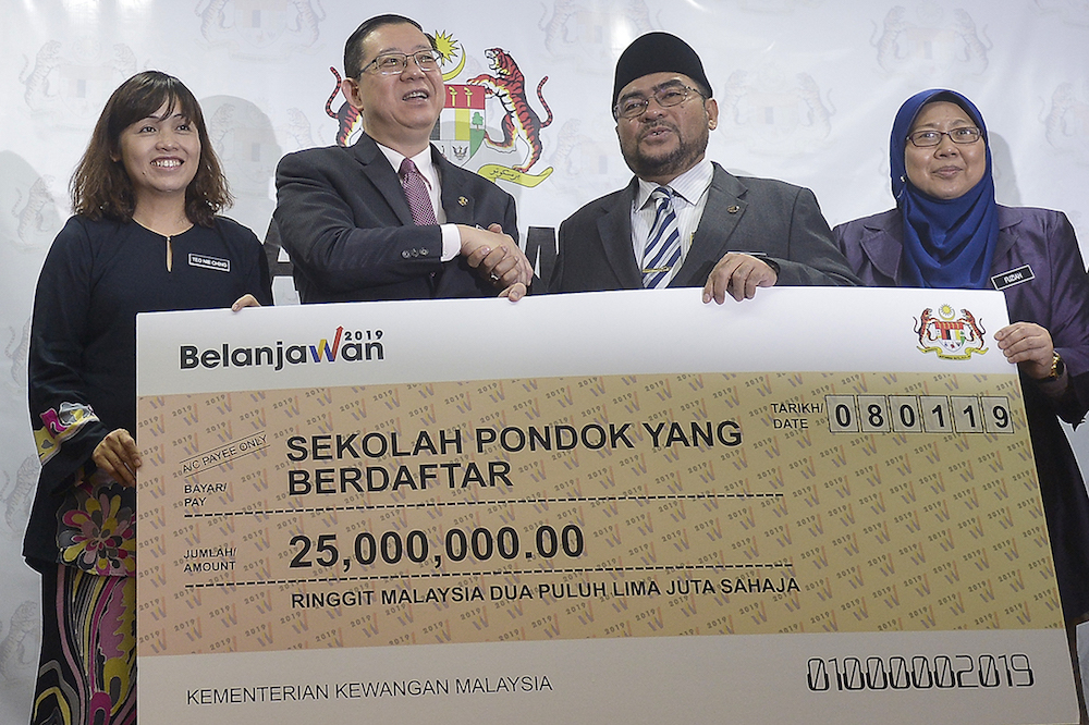 Lim Guan Eng and Datuk Seri Mujahid Yusof Rawa shake hands during the presentation of a mock cheque during a press conference at the Ministry of Finance in Putrajaya January 8, 2019. u00e2u20acu201d Picture by Mukhriz Hazim
