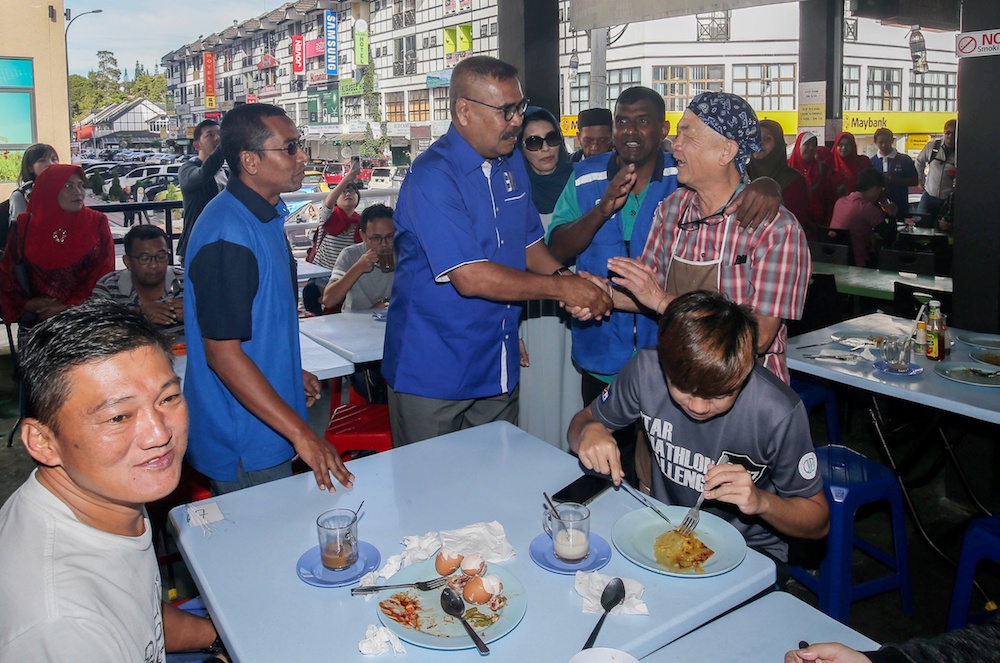 蓝利到丹那拉打的食肆，与选民打招呼。-Farhan Najib摄-