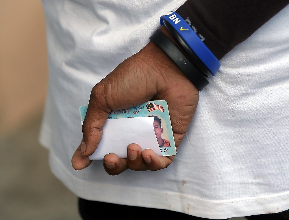 A man holds his MyKad as he waits in line to cast his vote at SJK (C) Bertam Valley in Cameron Highlands January 26, 2019. u00e2u20acu201d Picture by Farhan Najib