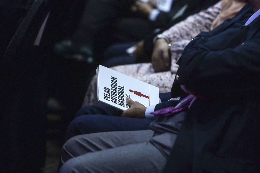 An attendee is pictured with a copy of the National Anti-Corruption Plan in Putrajaya, January 29, 2019. u00e2u20acu201d Picture by Shafwan Zaidon