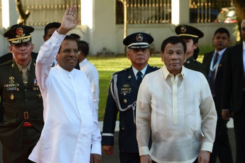 Sri Lankan President Maithripala Sirisena (left) waves to members of the media as Philippine President Rodrigo Duterte looks on during a welcoming ceremony at the Malacanang Palace grounds in Manila on Jan 16, 2019.PHOTO: AFP