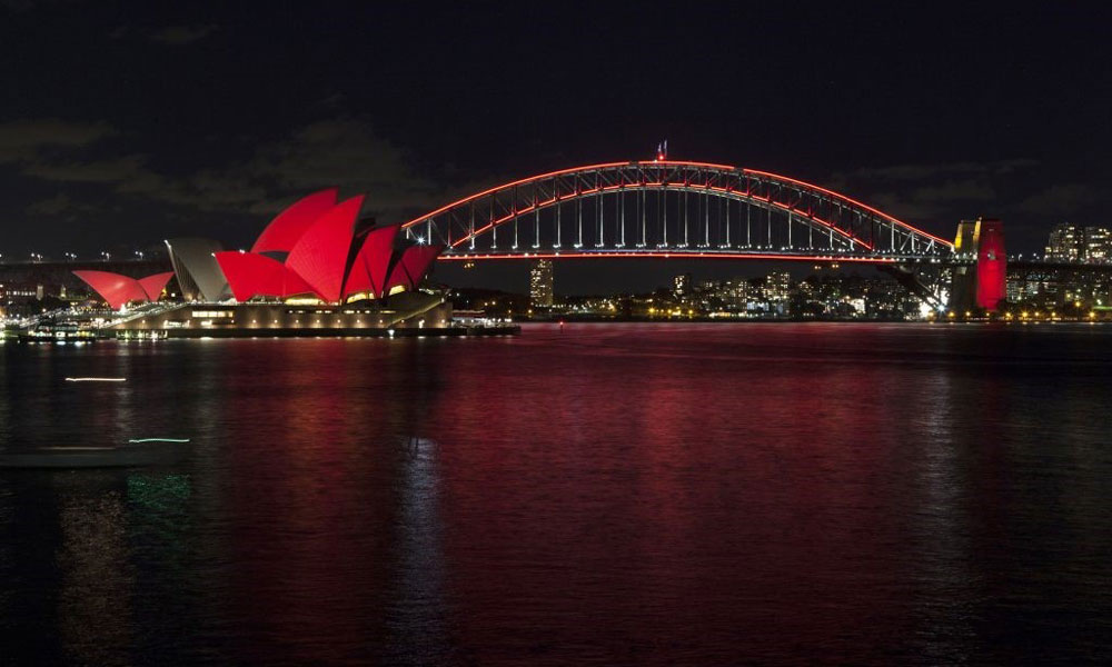 悉尼歌剧院和海港大桥同时点亮象征吉祥的红色照明，迎接农历春节。-图取自网络-