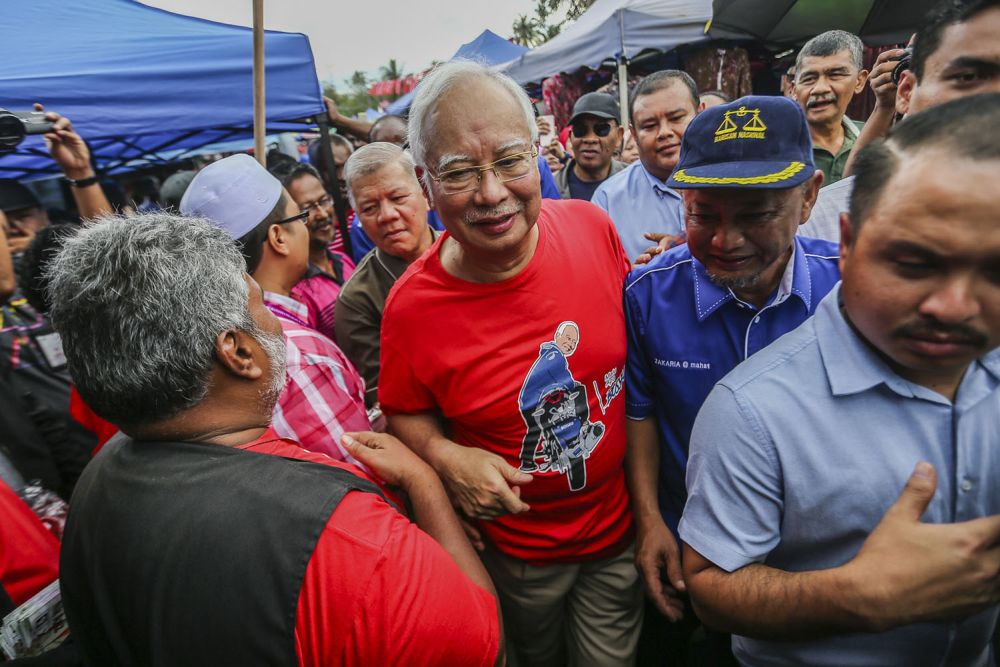 Datuk Seri Najib Razak (centre) and BN's candidate Zakaria Hanafi (right) greet supporters during a walkabout at the Pasar Tani Beranang in Semenyih February 20, 2019. u00e2u20acu2022 Picture by Hari Anggara