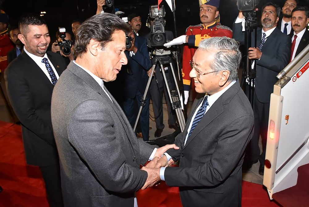 Pakistani Prime Minister Imran Khan receives his Malaysian counterpart Tun Dr Mahathir Mohamad on his arrival at Nur Khan Base in Rawalpindi March 21, 2019. u00e2u20acu201d AFP pic