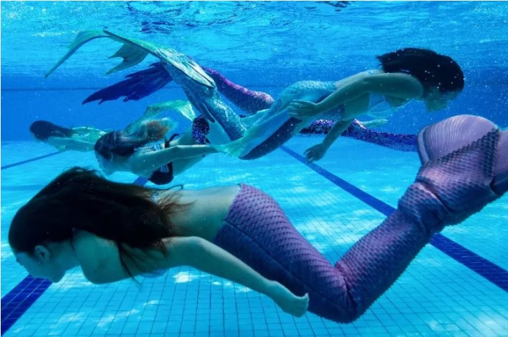 套着鱼尾要在水中游动不容易。-法新社-