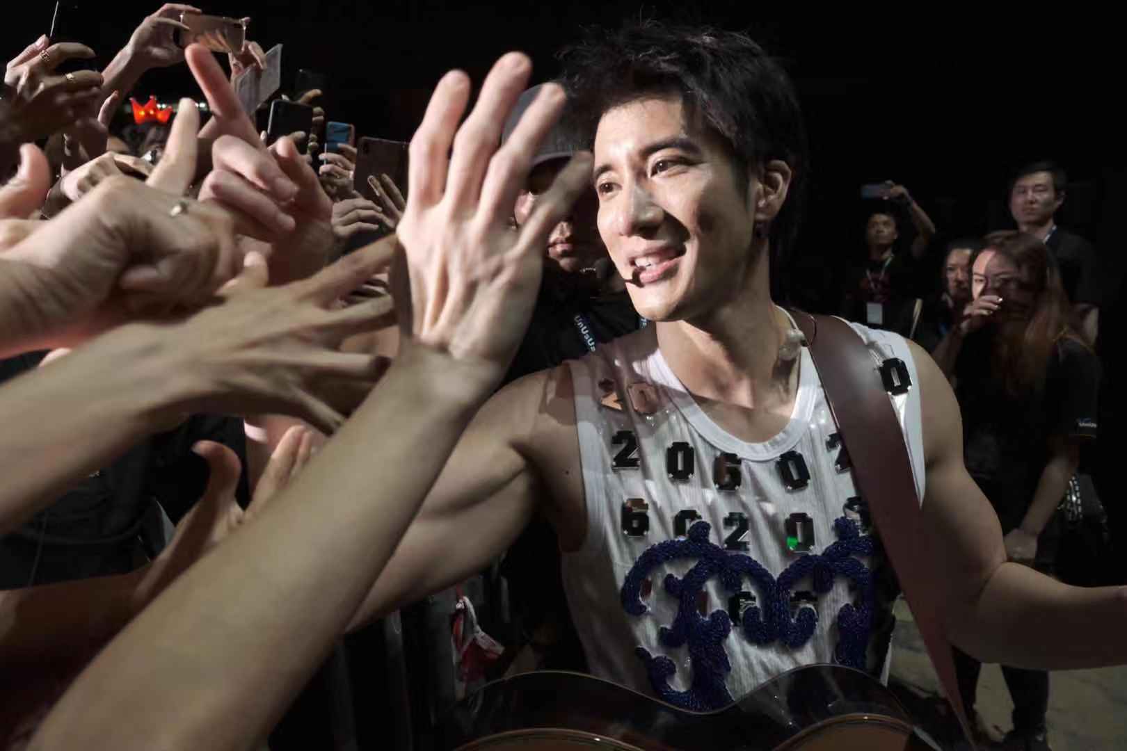 要与歌迷零距离的王力宏走下台与歌迷互动合唱握手还击掌。-星艺娱乐提供-