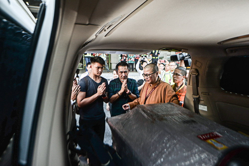 Datuk Teoh Yang Khoon (2nd left), whose wife Datin Tai Siew Kim was killed in the Lombok earthquake, offers prayers in front of her coffin after its arrival at the KLIA cargo terminal in Sepang March 19, 2019. u00e2u20acu201d Picture by Shafwan Zaidon
