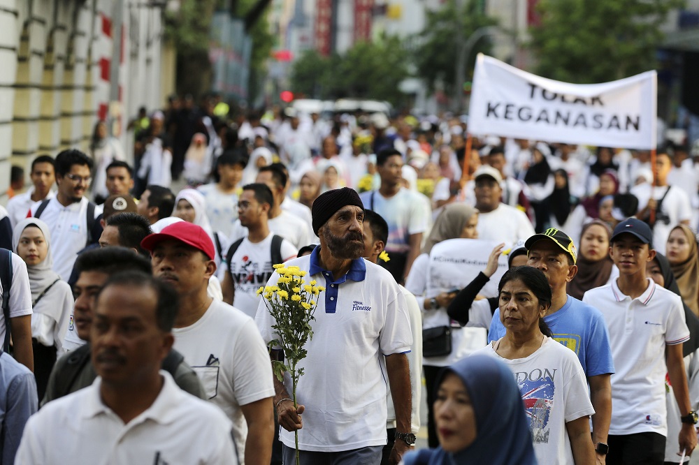 People hold flowers and banners as they march to Dataran Mardeka during the Solidarity 4 Peace Rally in Kuala Lumpur March 23, 2019. u00e2u20acu201d Picture by Yusof Mat Isa