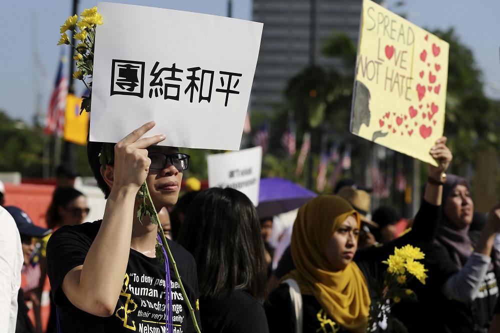 People hold flowers and placards as they march to Dataran Mardeka during the Solidarity 4 Peace Rally in Kuala Lumpur March 23, 2019. u00e2u20acu201d Picture by Yusof Mat Isa