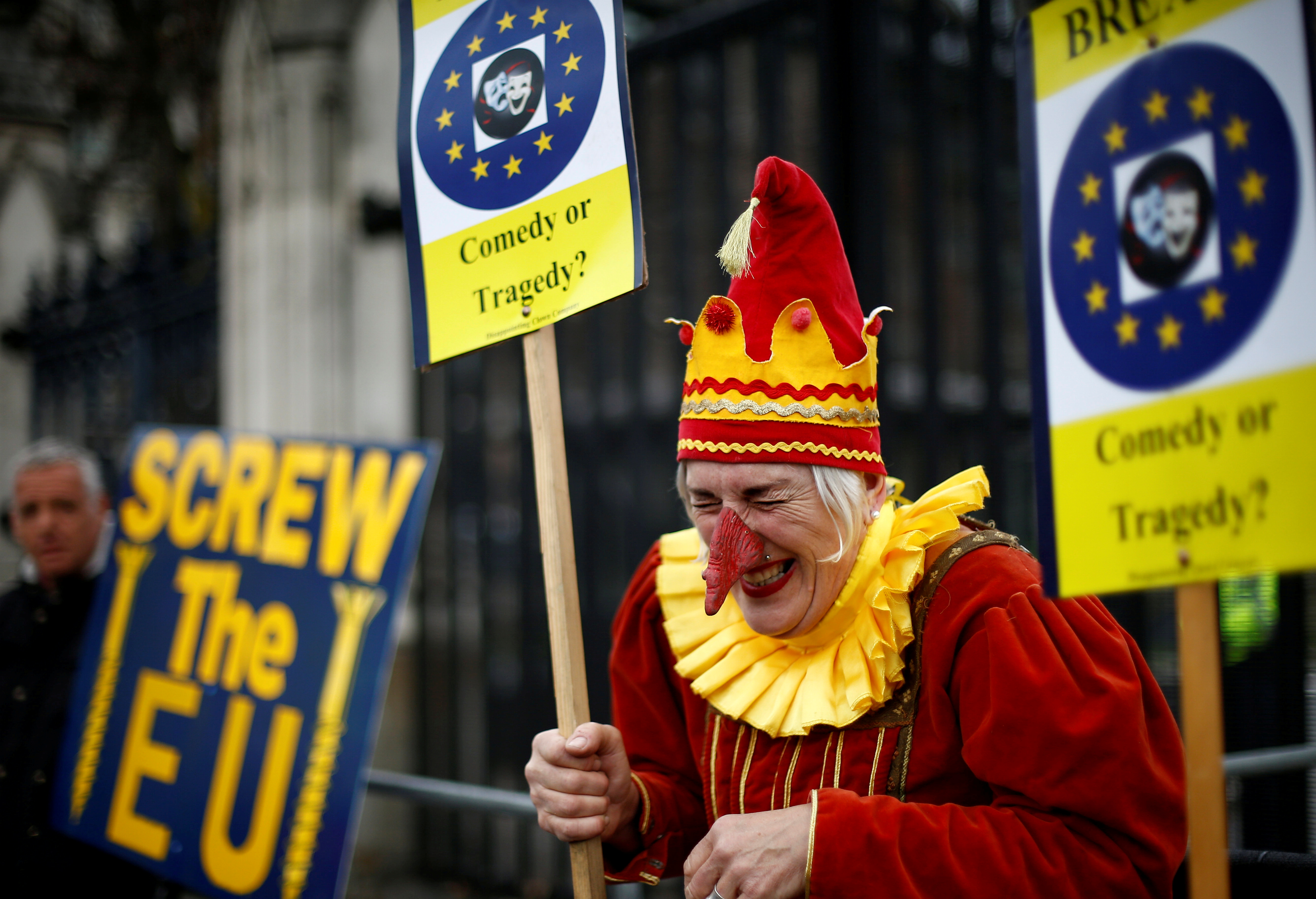 装扮成小丑的反脱欧示威者，周三在国会外高举写着“搞砸欧盟”、“戏剧或悲剧”，嘲讽英国脱欧进程陷入一团糟。-路透社-