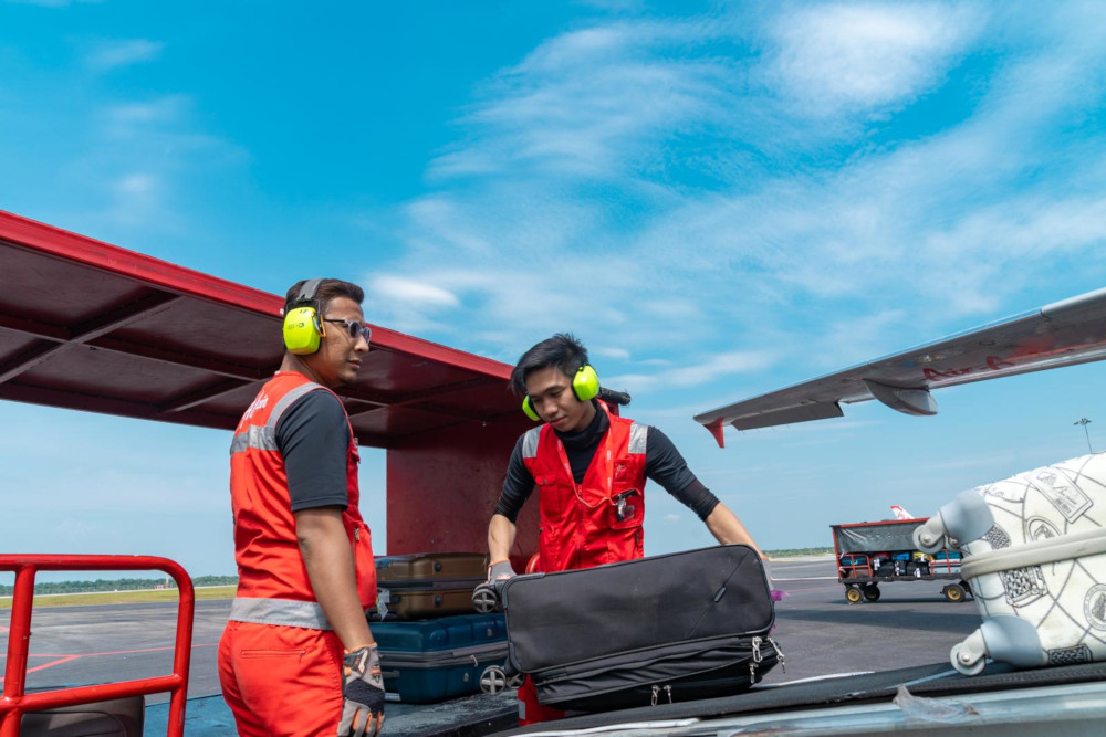Two GTR members handling passengersu00e2u20acu2122 baggage. u00e2u20acu201d AirAsia pic 