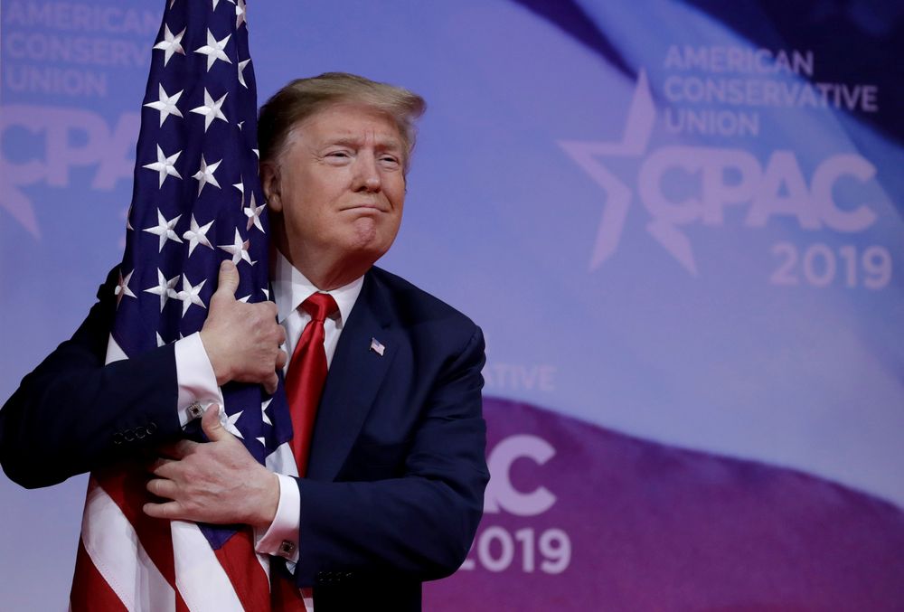 US President Donald Trump hugs an American flag at the Conservative Political Action Conference (CPAC) annual meeting at National Harbor near Washington, US, March 2, 2019.  u00e2u20acu201d Reuters pic