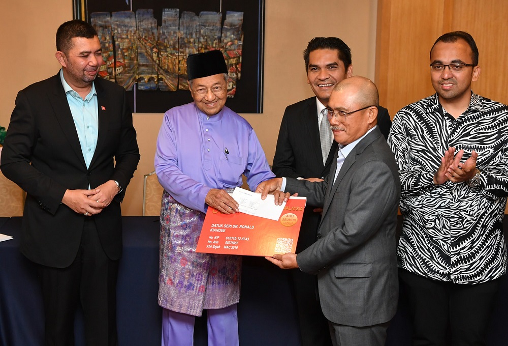 Datuk Seri Ronald Kiandee receives his Bersatu membership card from Tun Dr Mahathir Mohamad at the Perdana Leadership Foundation March 15, 2019. u00e2u20acu201d Bernama pic