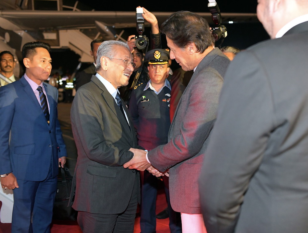 Prime Minister Tun Dr Mahathir Mohamad is greeted by Pakistani Prime Minister Imran Khan upon his arrival at the Pakistan Air Force Nur Khan airbase in Rawalpindi March 21, 2019. u00e2u20acu201d Bernama pic