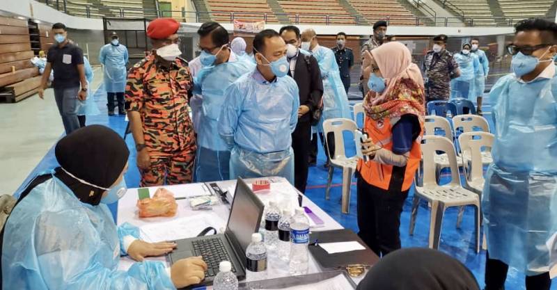 Education Minister Maszlee Malik (centre, in mask and gown) being briefed on the current situation during his visit at the Medic Base and Ground Control Centre at the Pasir Gudang Indoor Stadium today. u00e2u20acu201d Picture by Ben Tan