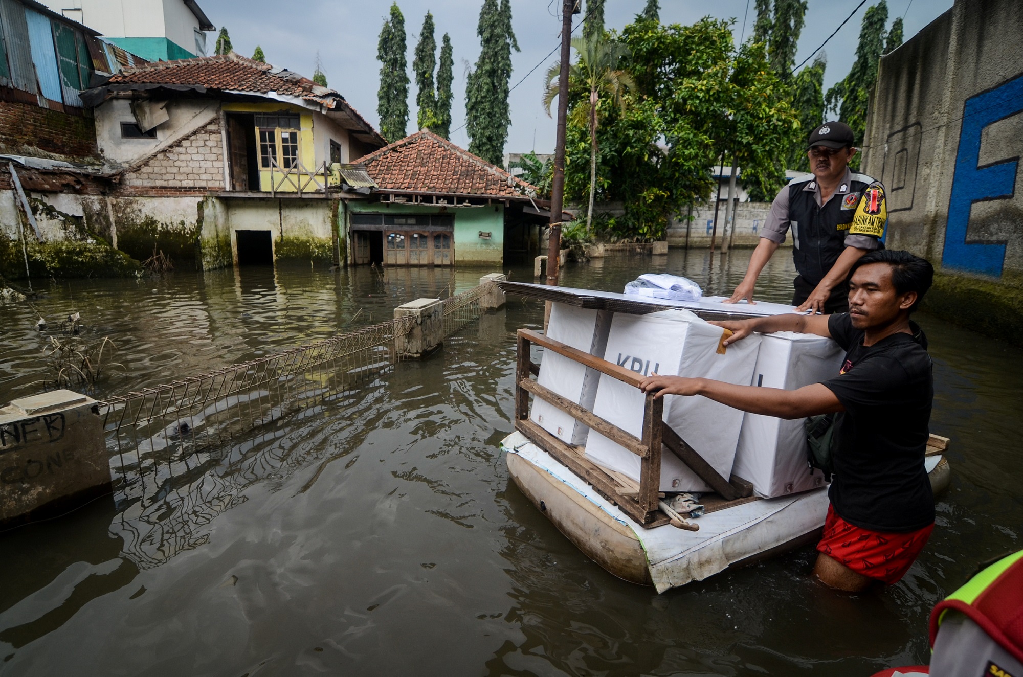 在印尼西爪哇省万隆市水灾灾区，官员通过橡皮筏运送投票箱和选举材料。-路透社/安塔拉通讯社-