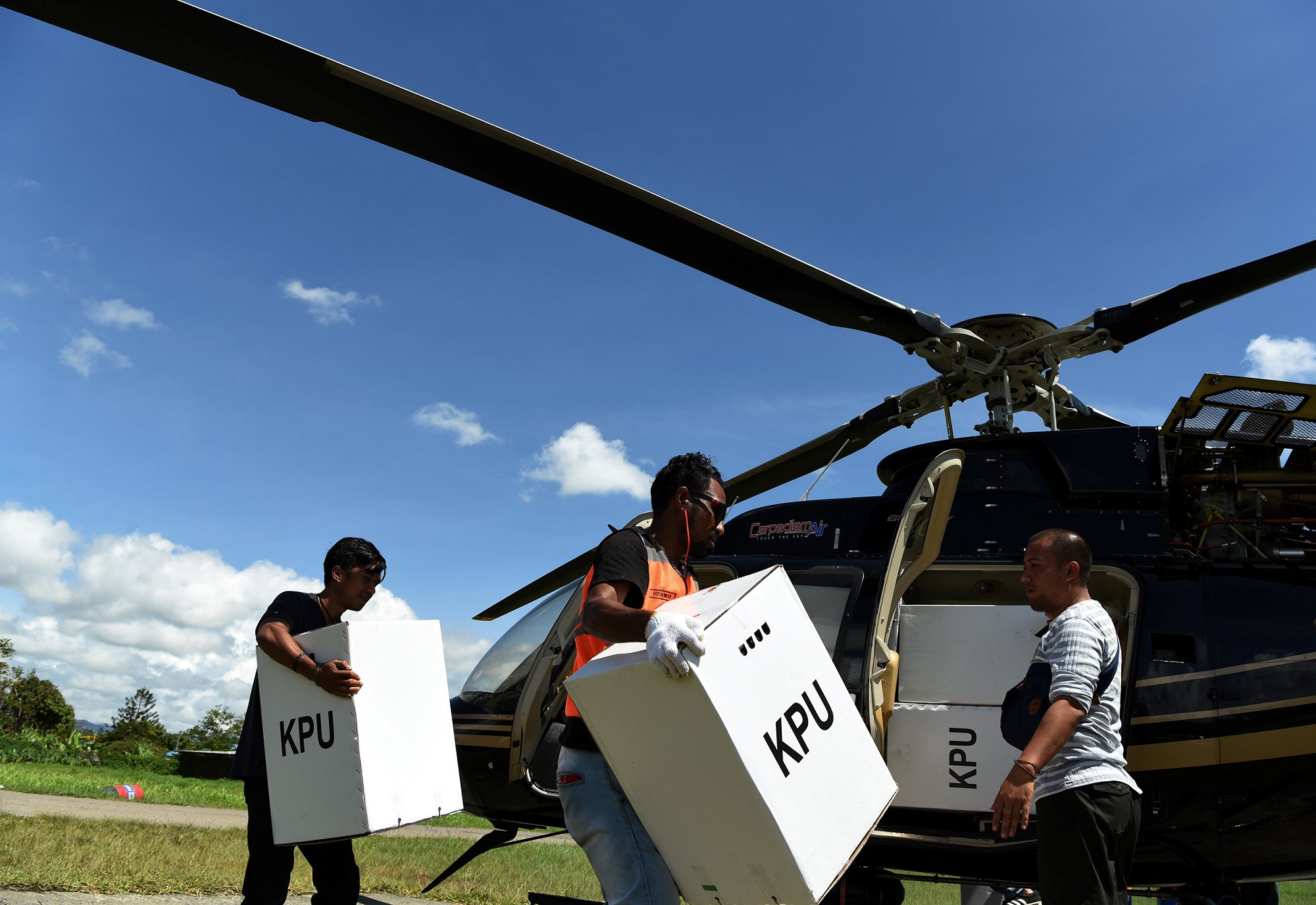 在印尼巴布亚省查亚维查亚县（Jayawijaya）的瓦梅纳（Wamena）机场，官员将选票箱和选举材料搬上直升机，准备运送到目的地。-路透社/安塔拉通讯社-