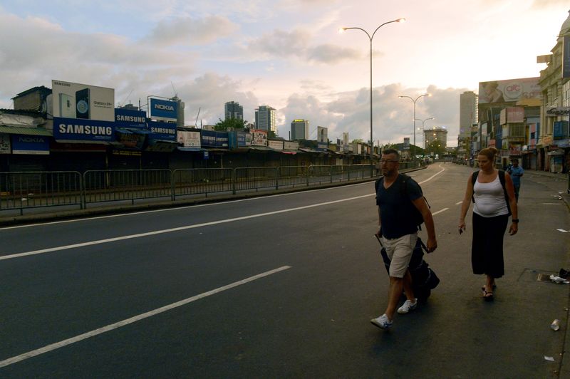Tourists walk along the road after the Sri Lanka Police curfew in Colombo on April 21.Photographer: Ishara S. Kodikara/AFP via Getty Images